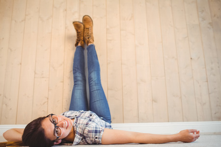 Pretty hipster with legs on wall on wooden planks backgroundの写真素材