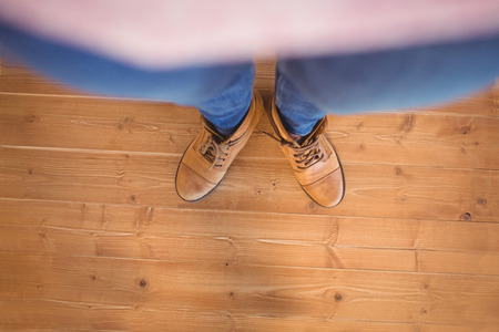 High angle view of woman wearing boots on wooden planks backgroundの写真素材