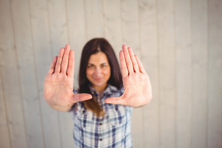 Pretty hipster holding hands up on wooden planks backgroundの写真素材
