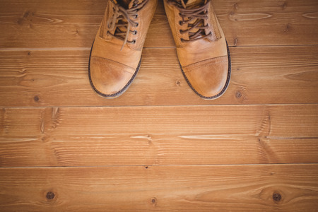 High angle view of woman wearing boots on wooden planks backgroundの写真素材