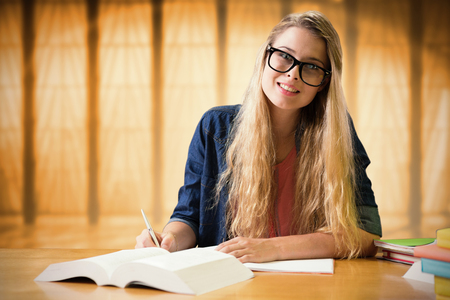 Student studying in the library  against window overlooking cityの写真素材