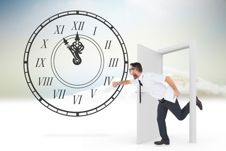 Geeky young businessman running late against open door in skyの写真素材