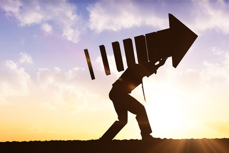 businessman with arrow against sun shiningの写真素材