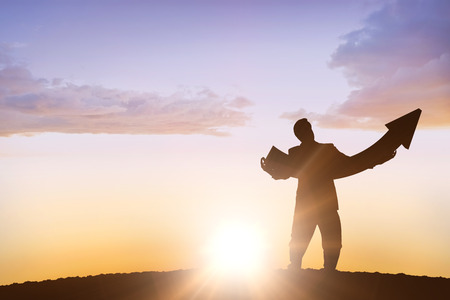 businessman with arrow against sun shiningの写真素材