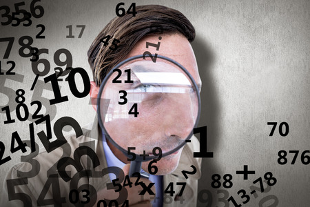 Spy looking through magnifier against white and grey backgroundの写真素材