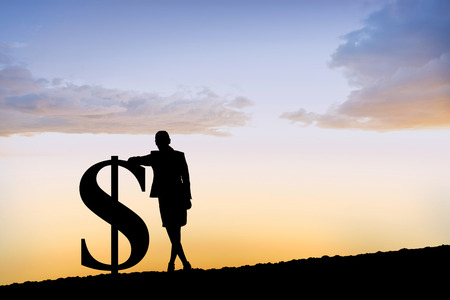 Silhouette beside dollar symbol against sun shiningの写真素材