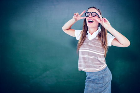 Happy geeky hipster dancing against green chalkboardの写真素材