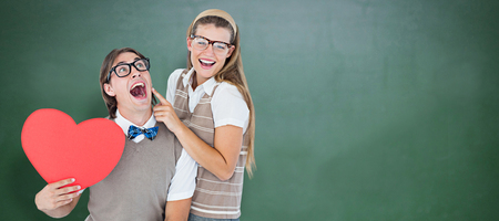 Excited geeky hipster and his girlfriend  against green chalkboardの写真素材