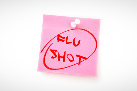 flu shots against pink adhesive note with pushpinの写真素材