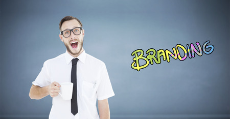 Geeky smiling businessman holding mug against dark roomの写真素材