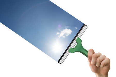 Hand using wiper against blue sky with clouds