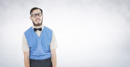 Geeky hipster pulling a silly face against white wallの写真素材