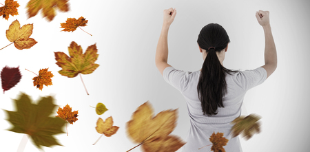Depressed woman standing back to camera against autumn leavesの写真素材