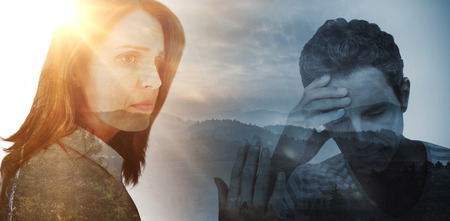 Upset man with hand on forehead against trees and mountain range against cloudy skyの写真素材