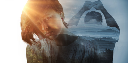Upset man leaning on white background against trees and mountain range against cloudy skyの写真素材