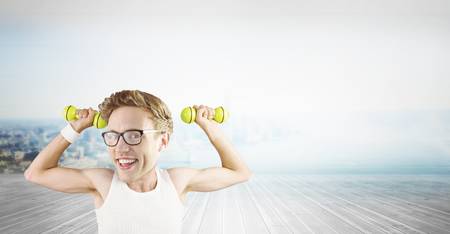 Nerd lifting weights against city scene in a roomの写真素材