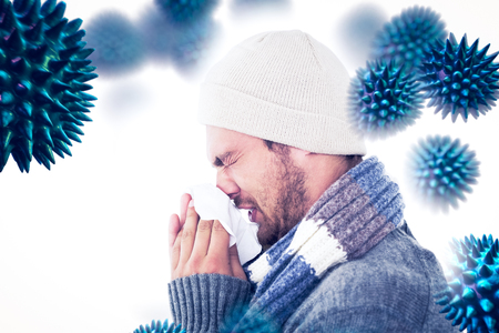 Handsome man in winter fashion blowing his nose against virusの写真素材