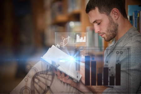 Digital representation of pie chart against serious male student reading a bookの写真素材