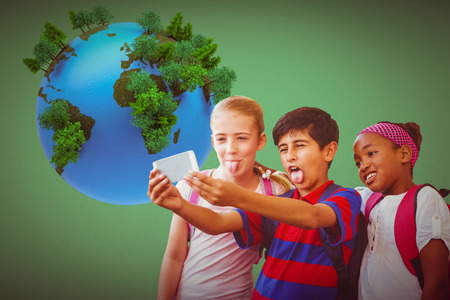 School kids taking selfie in school corridor against greenの写真素材