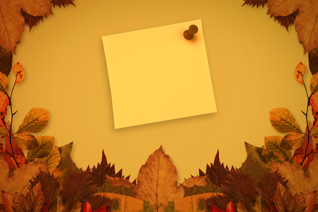 Yellow pinned adhesive note against autumn leaves pattern