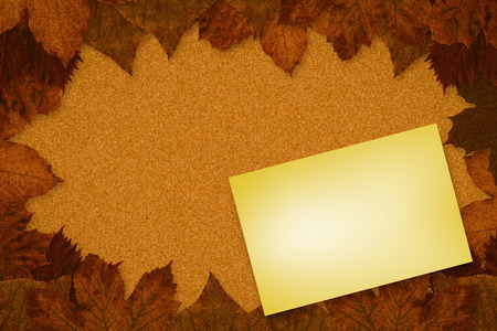 Yellow card against autumn leaves patternの写真素材