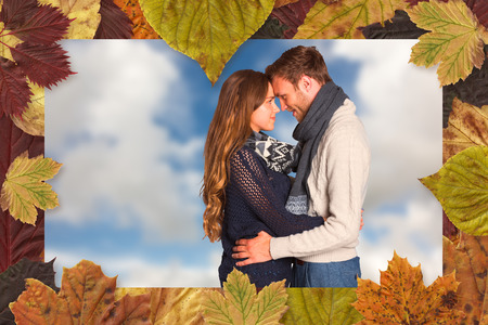 Side view of young couple embracing against blue sky with white cloudsの写真素材