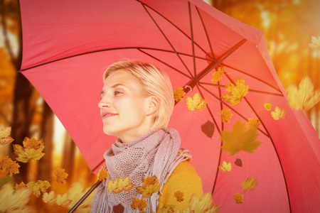 Happy woman keeping dry against autumn sceneの写真素材
