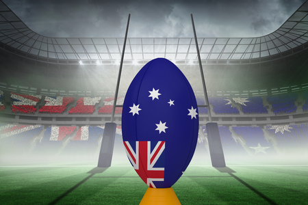 Australian flag rugby ball on stand against rugby pitchの写真素材