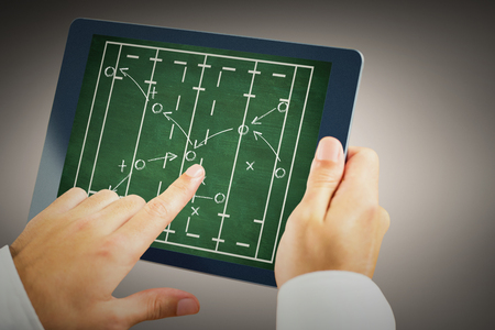 Man using tablet pc against rugby tacticsの写真素材