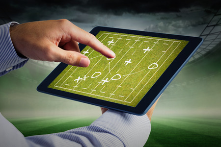 Man using tablet pc  against rugby tacticsの写真素材