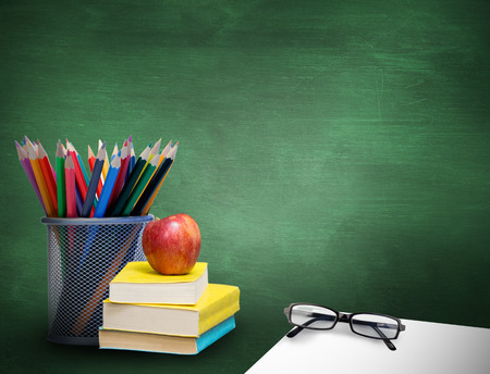 School supplies against green chalkboardの写真素材