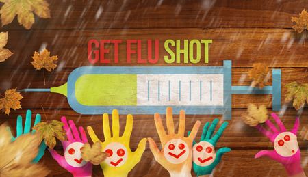 Hands with colourful smiley faces against overhead of wooden planksの写真素材