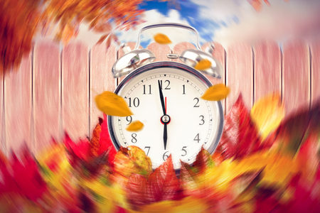 Alarm clock against fence under blue skyの写真素材