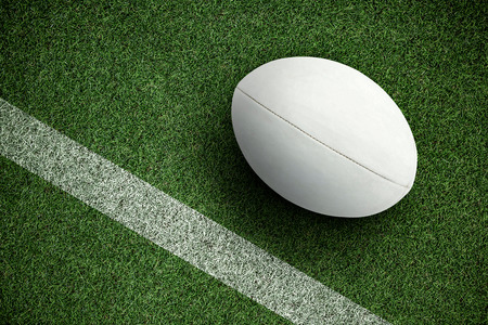 Close-up of rugby ball against pitch with lineの写真素材