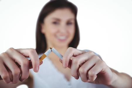 Woman snapping cigarette in half on white backgroundの写真素材