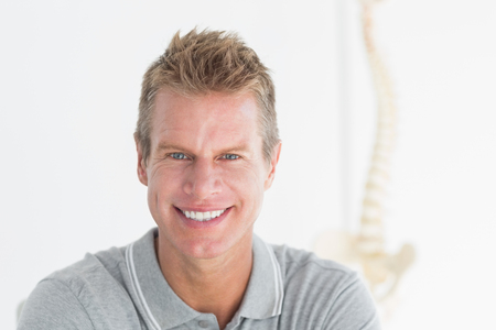 Happy doctor looking at camera in medical officeの写真素材