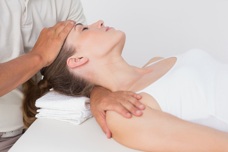 Woman receiving neck massage in medical officeの写真素材