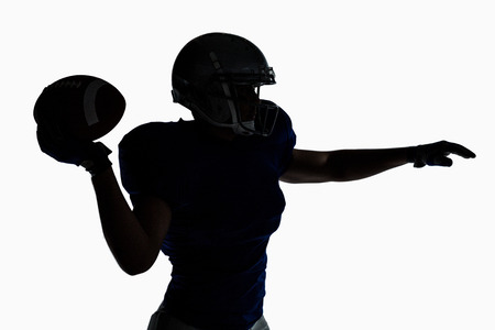 Silhouette American football player throwing ball against white backgroundの写真素材