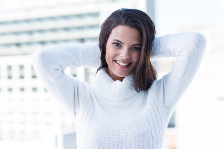 Pretty brunette smiling at camera with heads on head outsideの写真素材