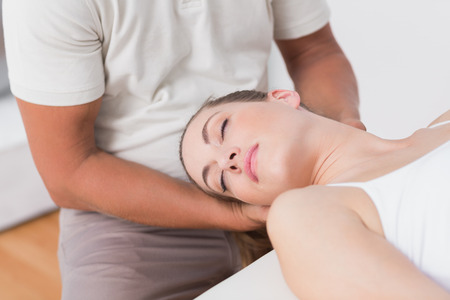 Woman receiving neck massage in medical officeの写真素材
