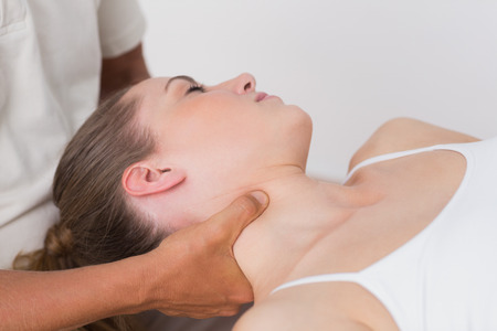 Woman receiving neck massage in medical officeの写真素材
