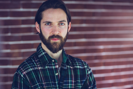 Portrait of confident man against brick wall