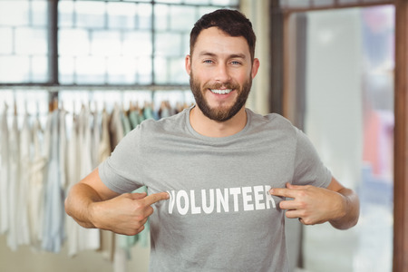 Man showing volunteer text on tshirt in office