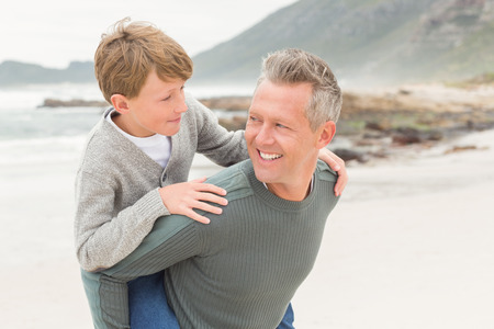 Young boy with his father at the beachの写真素材