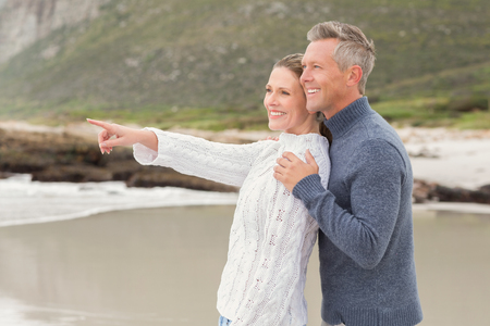 Cute couple standing and holding each other at the beachの写真素材