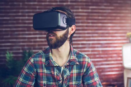 Creative businessman wearing 3D video glasses while looking away at office