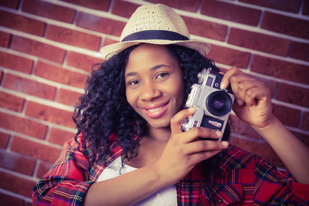 Hipster taking a photo on red brick background
