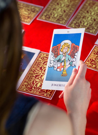 Fortune teller using tarot cards on red tableのeditorial素材