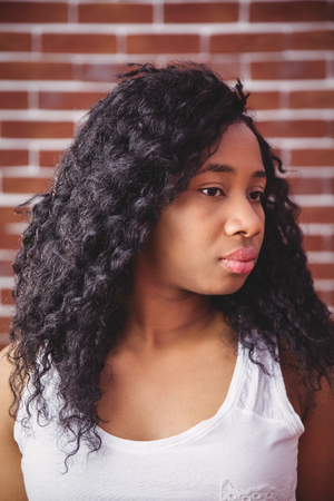 Young woman posing looking to side on red brick backgroundの写真素材