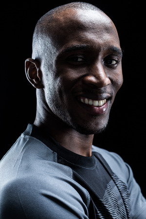 Portrait of happy rugby player against black backgroundの写真素材